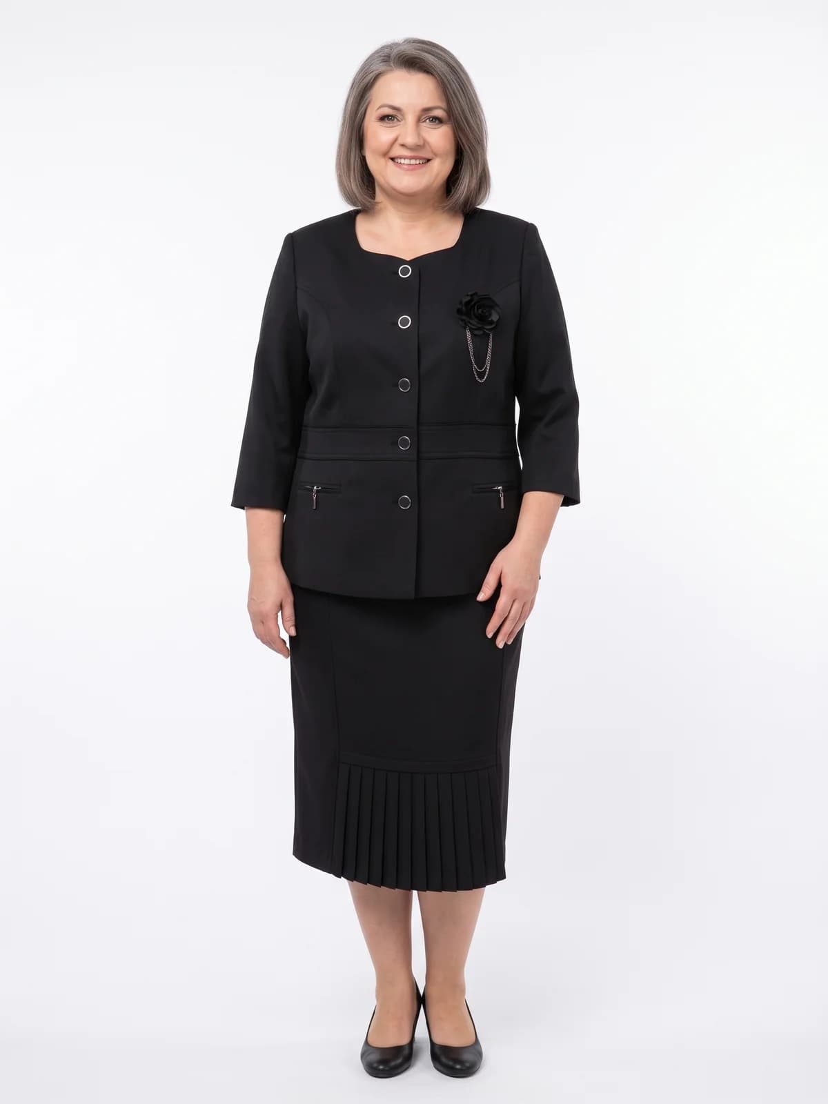 Costum negru cu jachetă cu nasturi argintii, broșă floare și fustă midi plisată